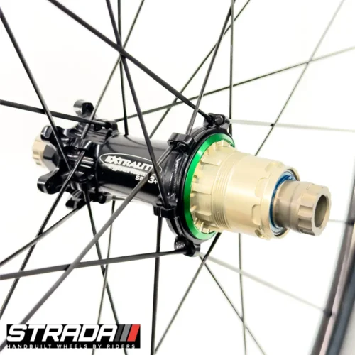 A picture showing a black Extralite SPD3+ bicycle hub laced to a Strada Performance Aero Disc brake 60 Ultra Gloss carbon front bicycle wheel.