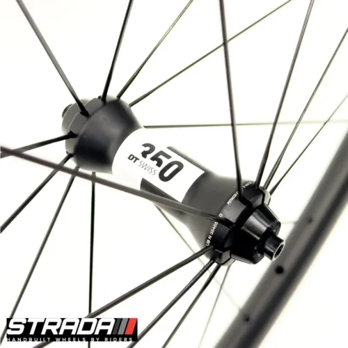 A picture showing a black and white DT Swiss 350 Road bicycle hub laced to a Strada Performance Aero Rim brake 35 Ultra carbon front bicycle wheel.